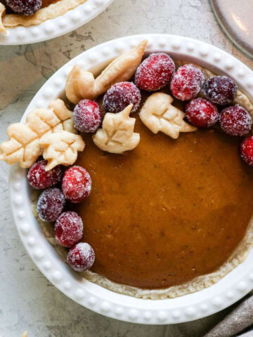 mini pumpkin pie topped with frosted cranberries.