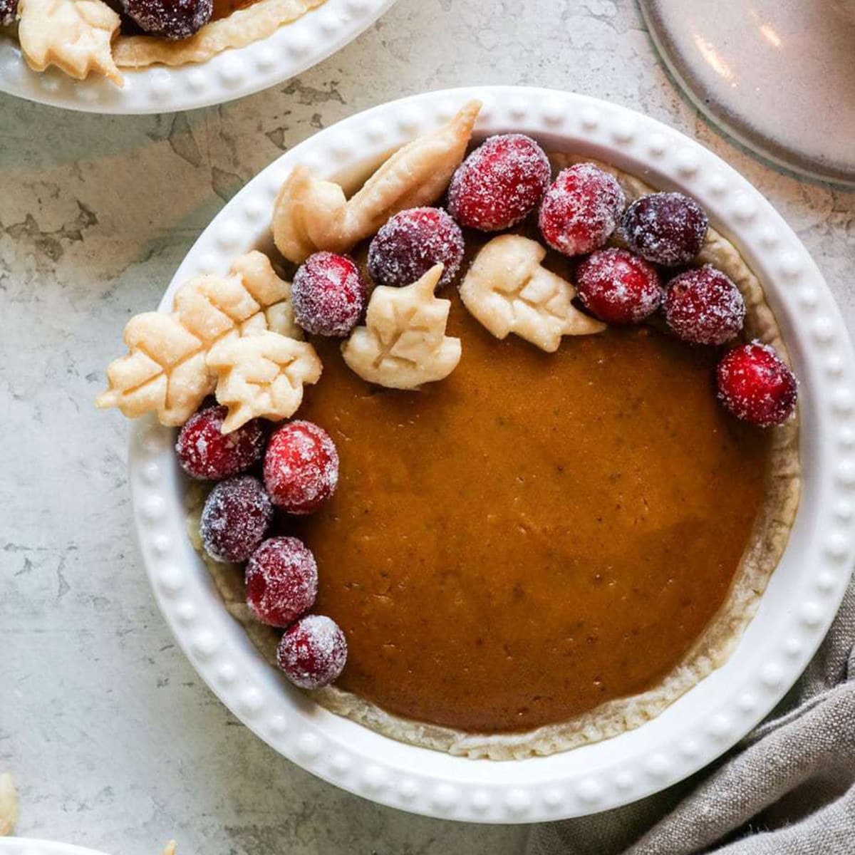 mini pumpkin pie topped with frosted cranberries.