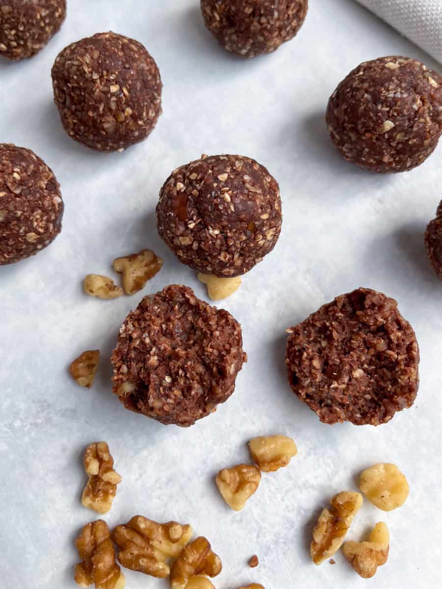 close up of the raw cacao energy balls and a few scattered walnuts. 