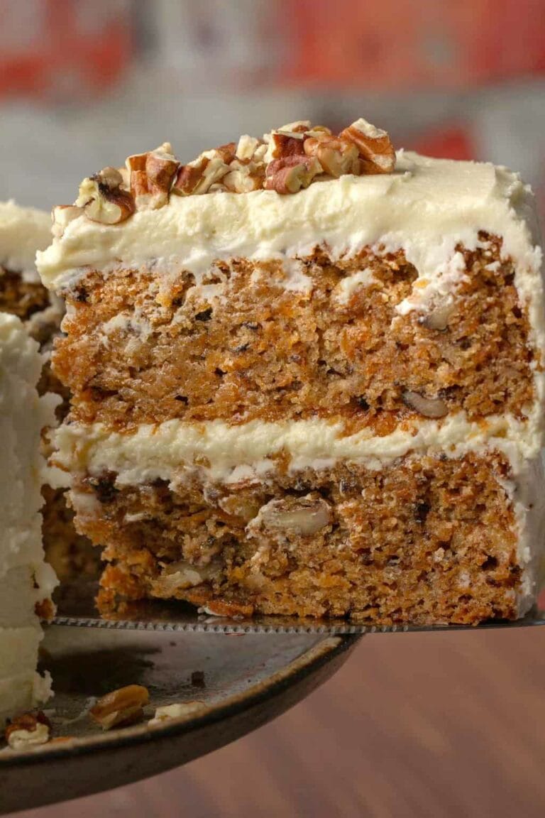 Gluten-free vegan carrot cake with white frosting and walnuts. 